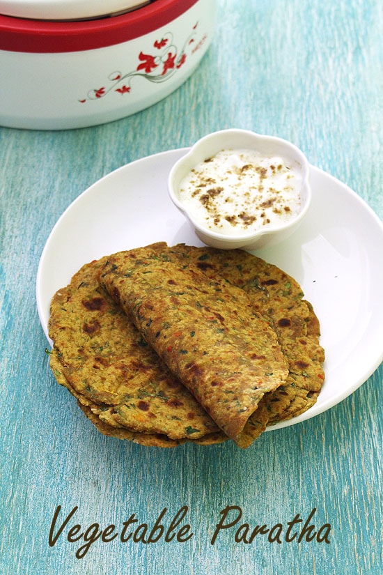 Vegetable paratha served with a bowl of yogurt.