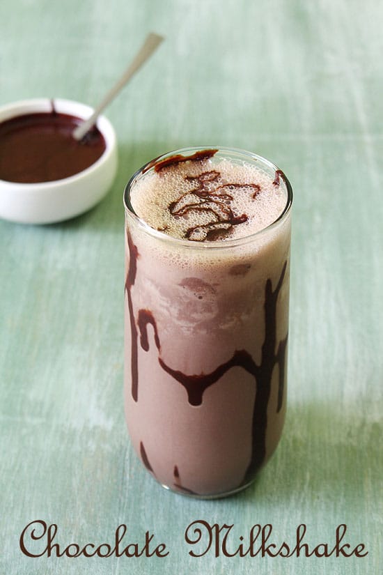 Chocolate milkshake in a tall glass wit ha drizzle of chocolate sauce.