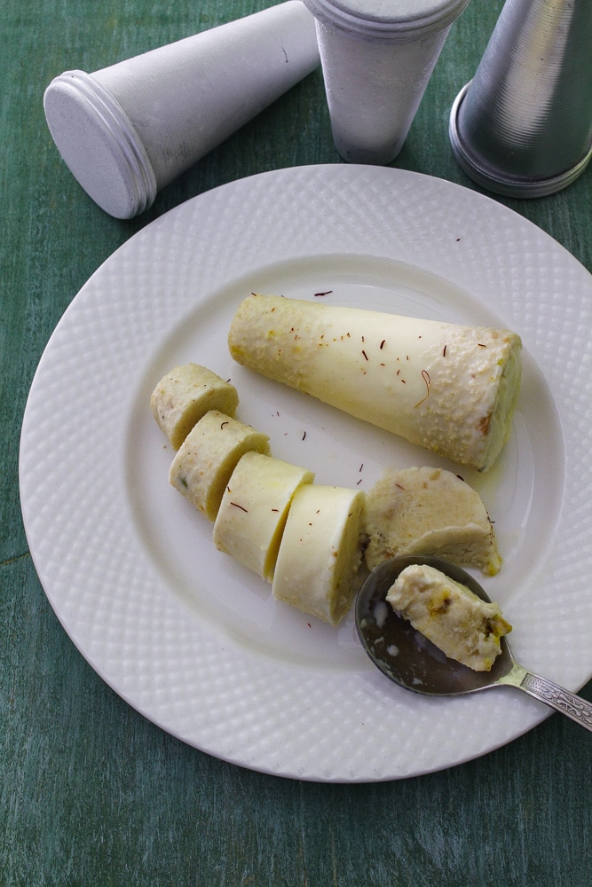 Taking a bit of kulfi using a spoon.