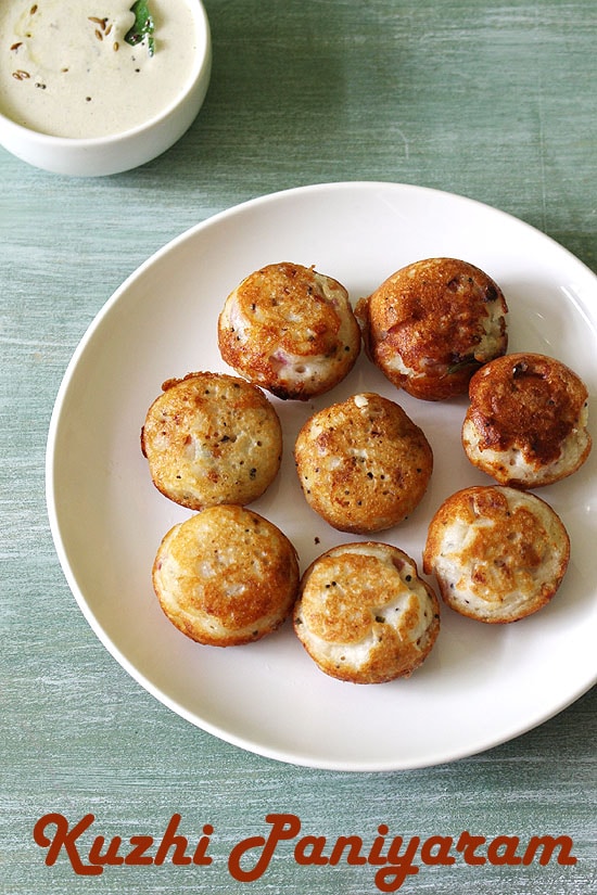 Paniyaram served in a plate with peanut chutney in the back.