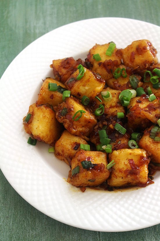 Paneer manchurian dry garnished with spring onoin greens.