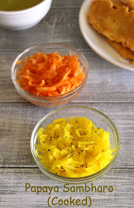 2 types of papaya sambharo in small bowls with fafda in the back.