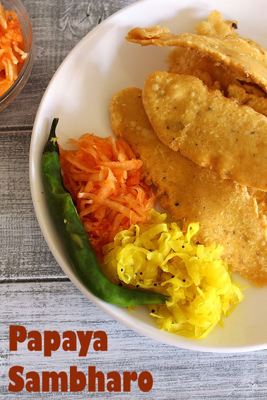 2 types of papaya sambharo served in a plate with fafda and fried chili.