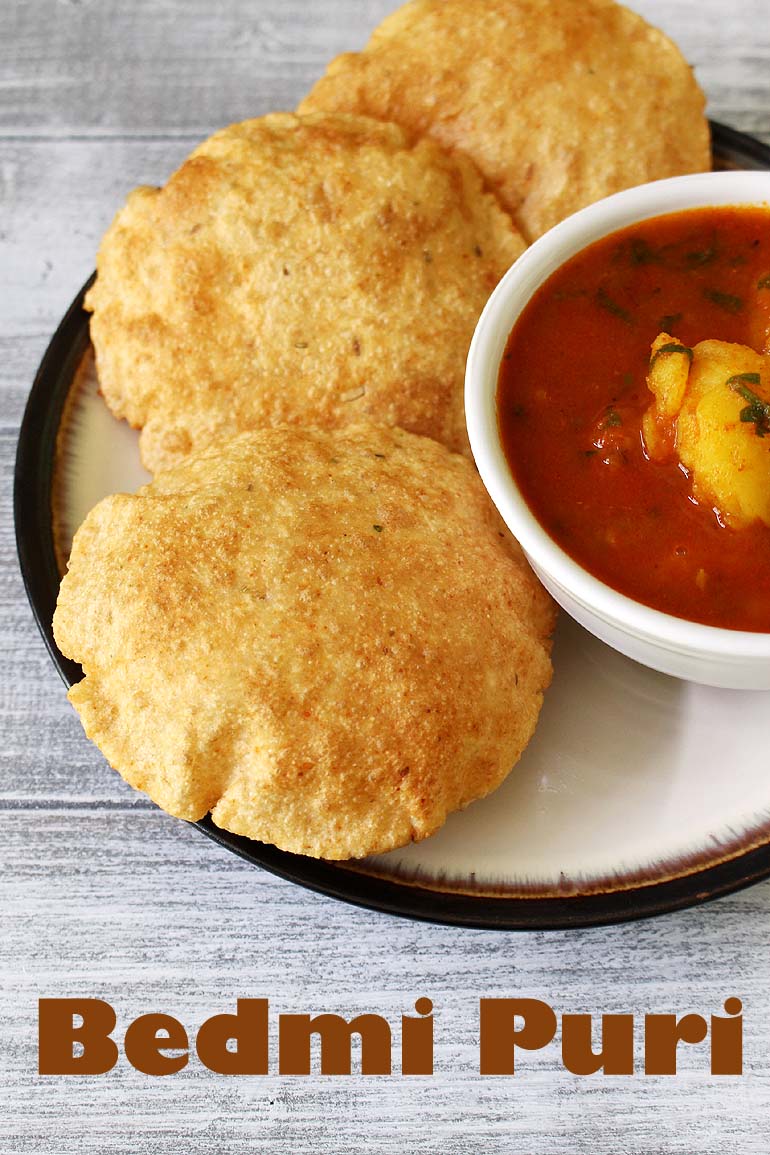 3 bedmi puri on a plate with bedmi aloo sabzi on the side.