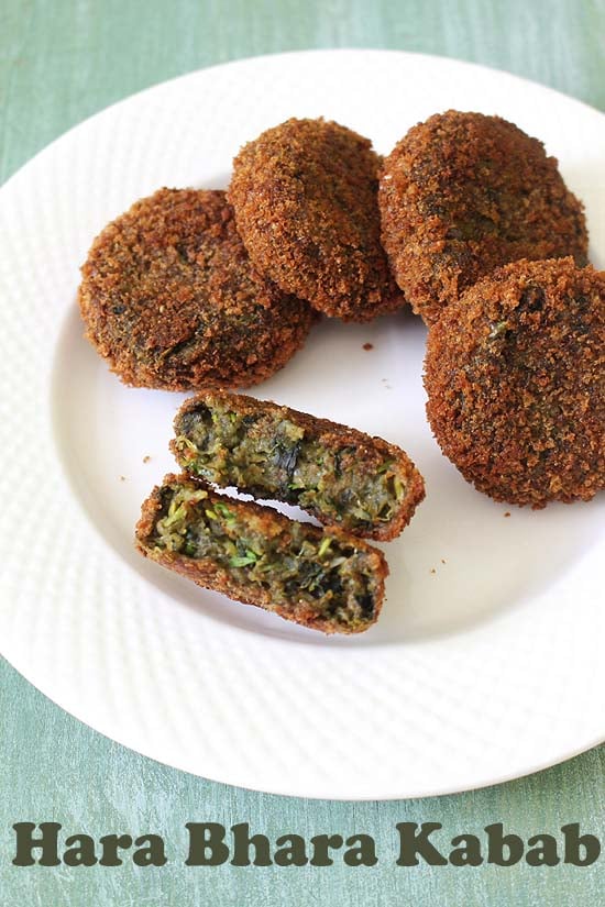 Hara bhara kabab cut into half and other 4 also served on a plate.