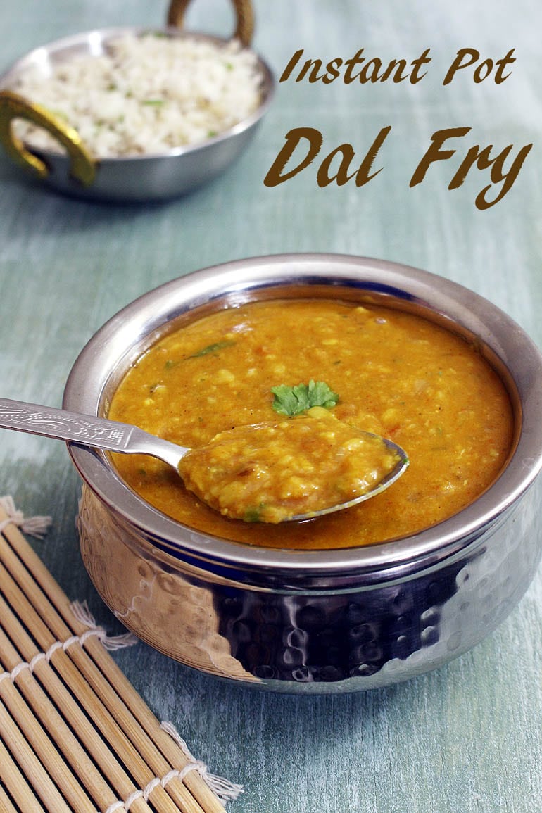 A spoonful of dal fry is taking away from a serving handi.