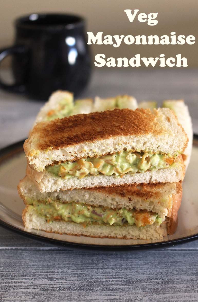 veg mayonnaise sandwich stack served on a plate with a mug in the back.