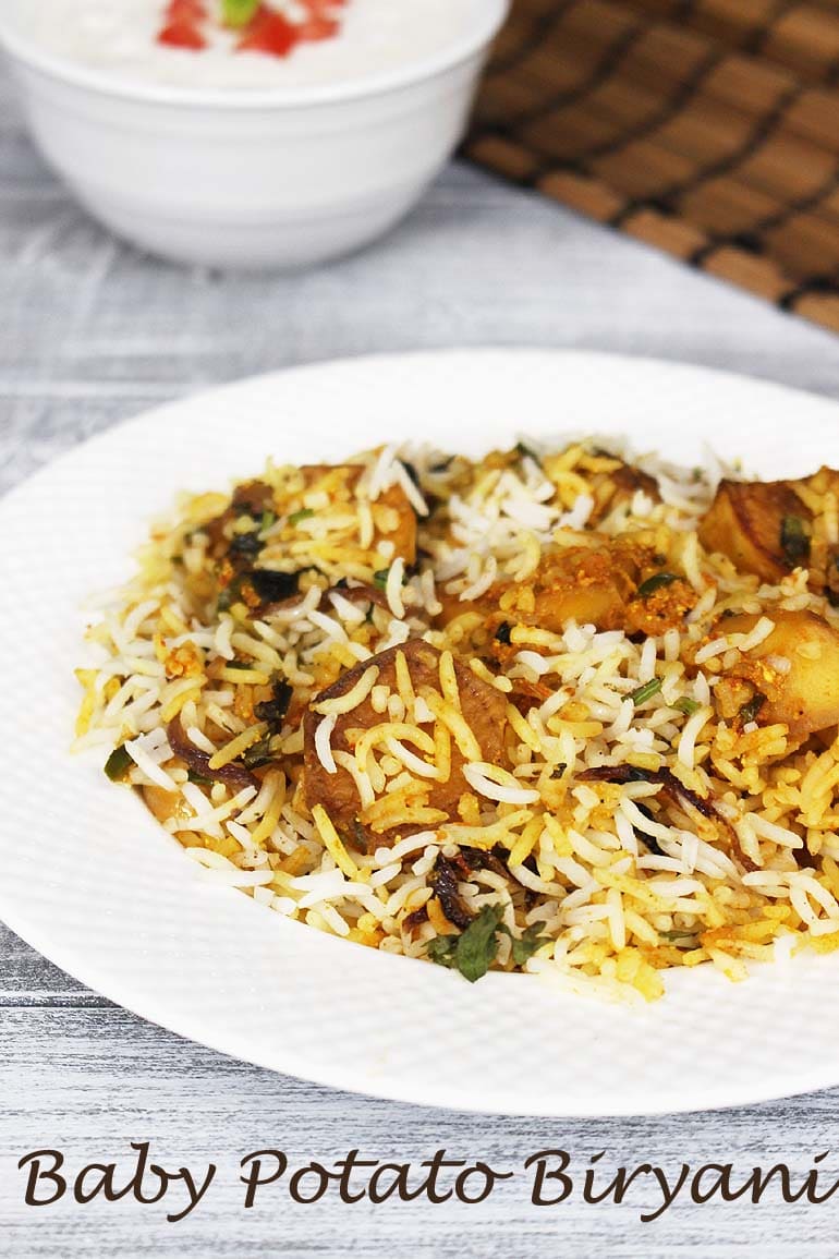 Baby potato biryani served in a white plate.