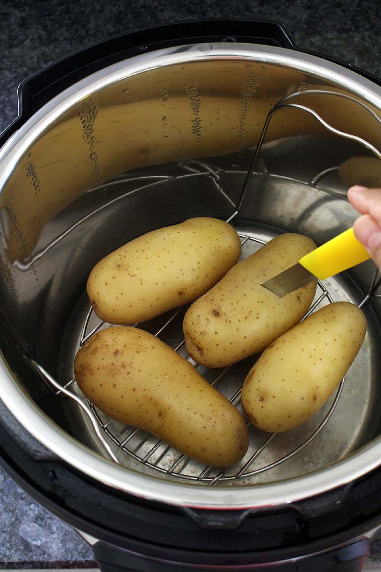 Checking the doneness of potato by inserting a knife.