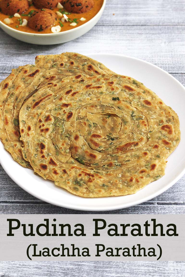 pudina paratha in a plate with kofta curry in the back.