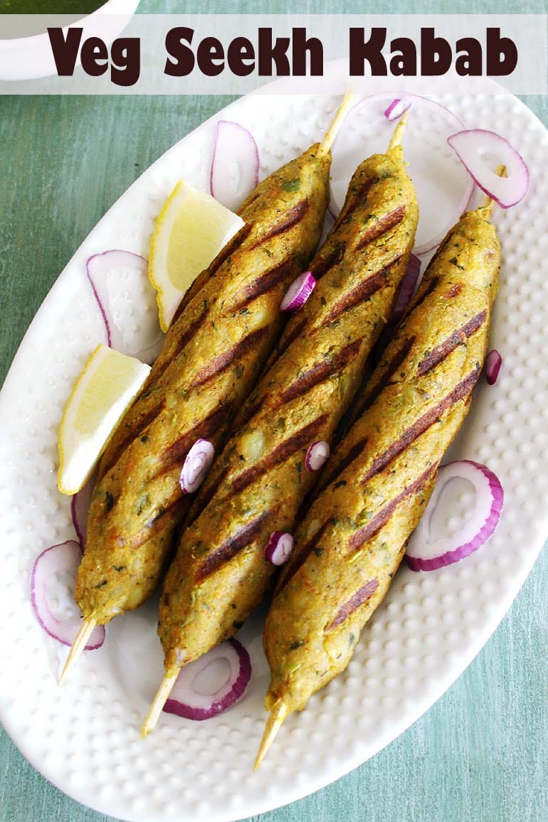 Veg kabab served in an oval plate with onions and lemon wedges.