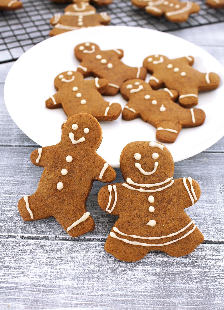 Eggless gingerbread men cookies leaning on a plate.