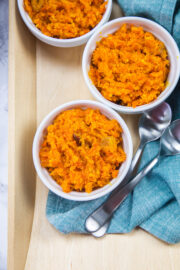 3 bowls of carrot halwa in a tray with spoons.