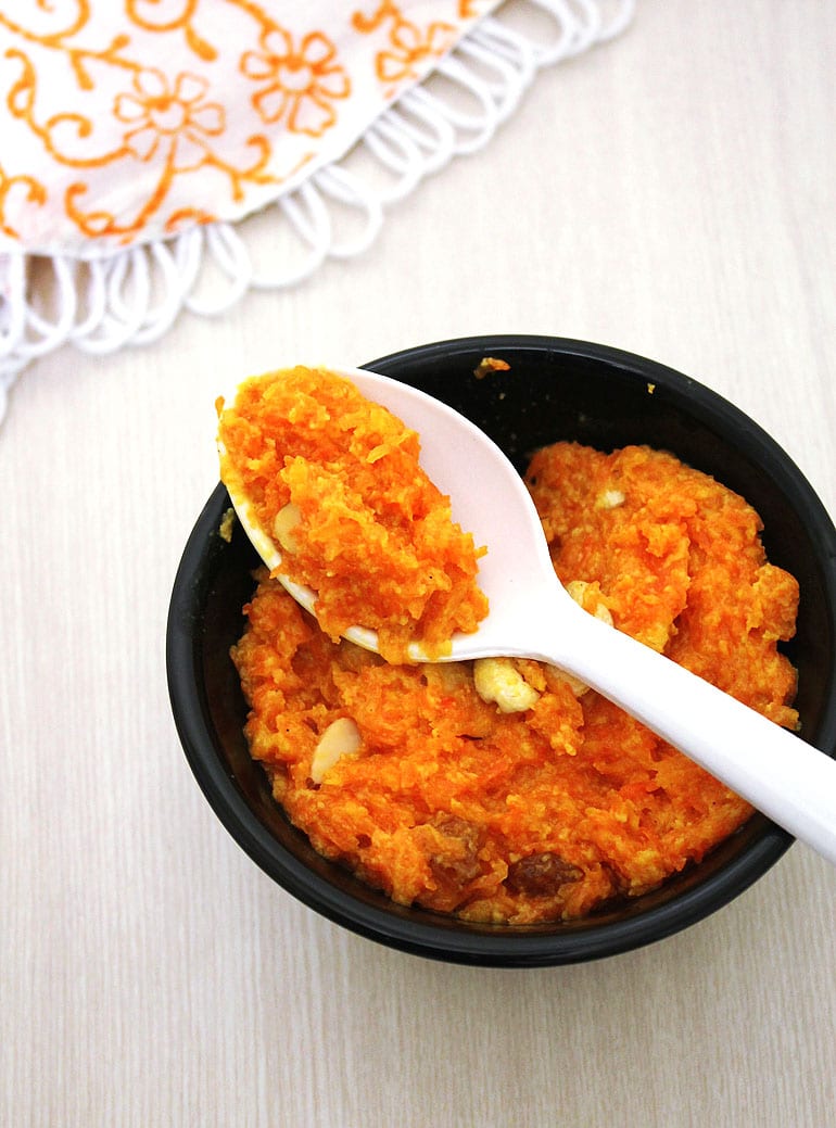 A spoon of carrot halwa taking from the bowl.