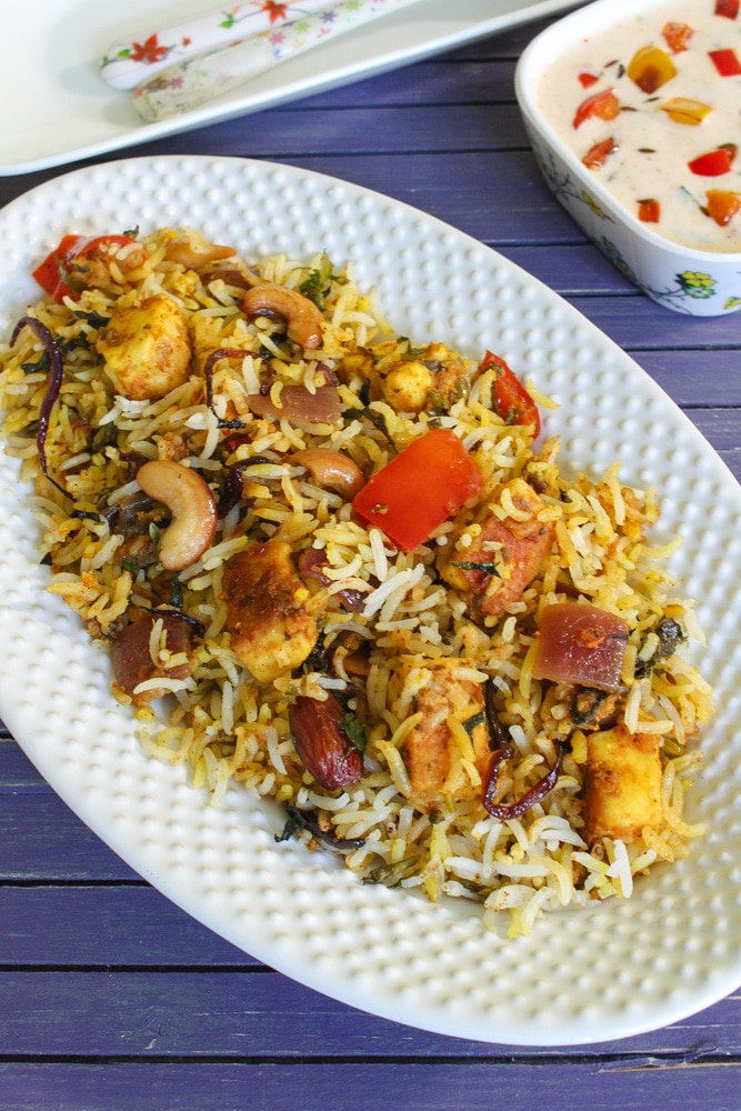 Paneer biryani served with capsicum raita.