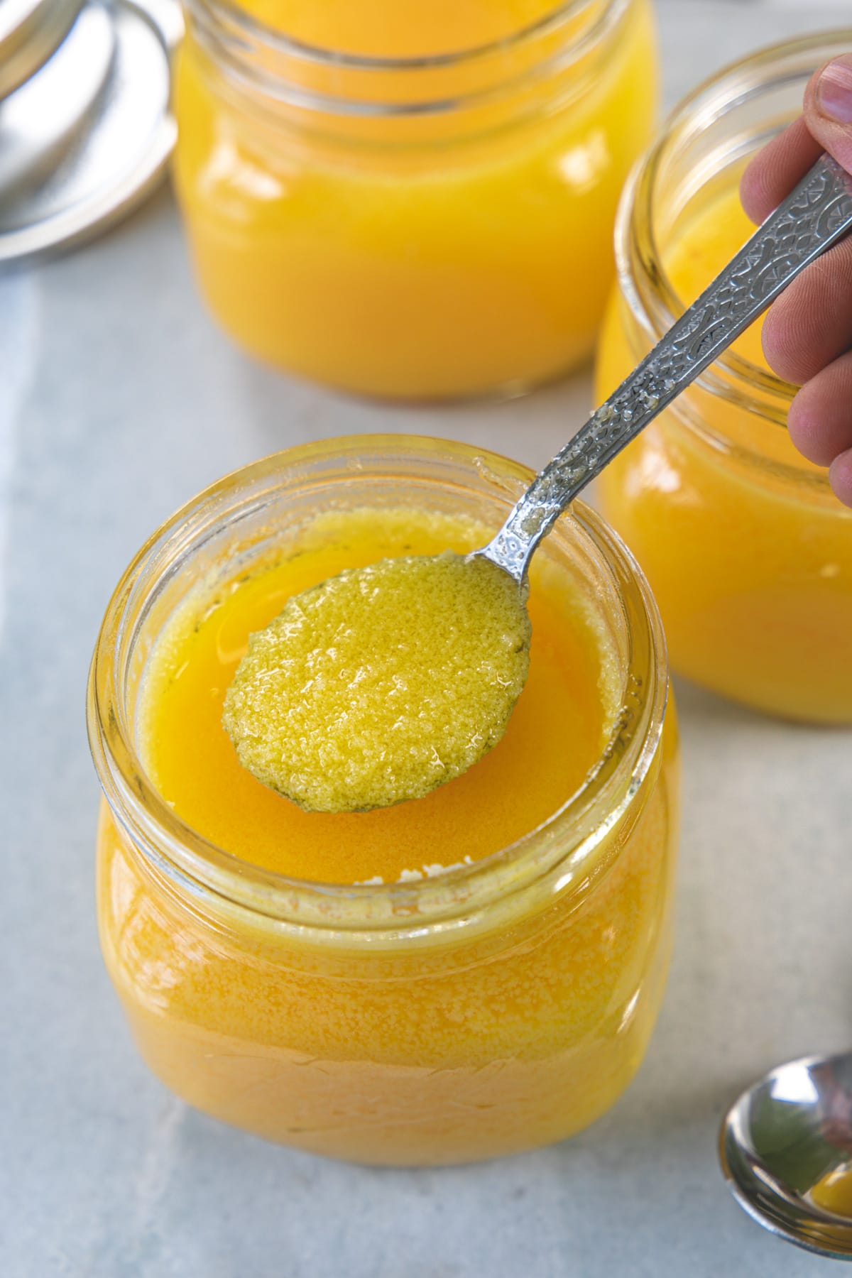 Spoonful of ghee taking from the jar.