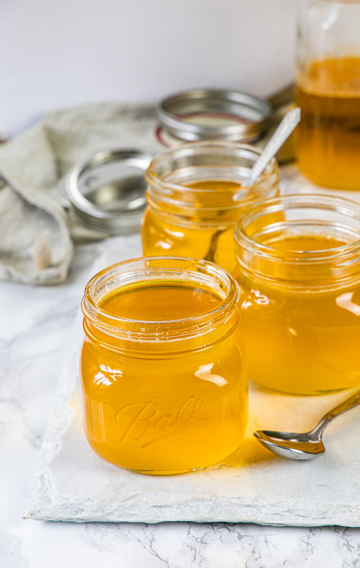 4 jar of homemade ghee with a spoon on the side.