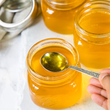 Taking spoon ful of melted ghee from the jar.