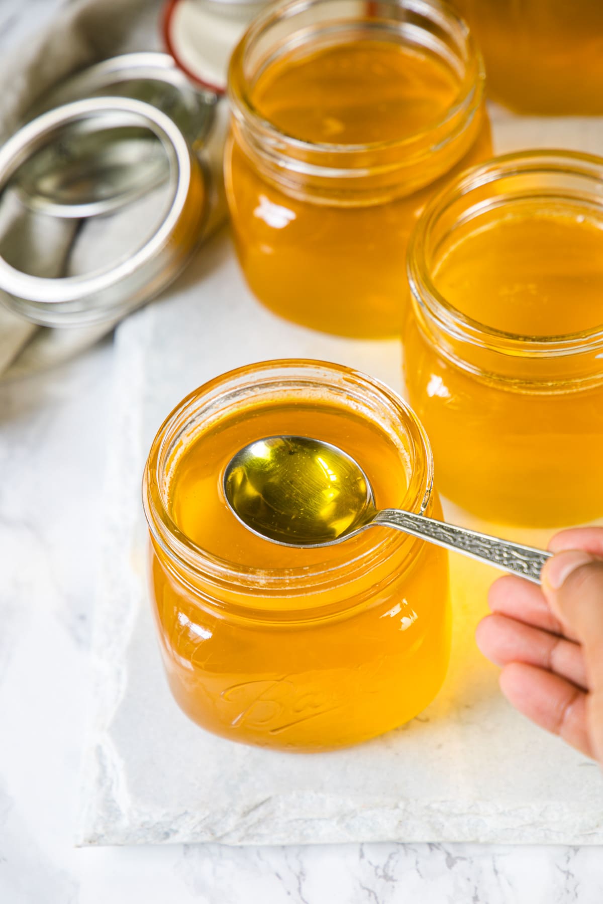 Taking spoon ful of melted ghee from the jar.