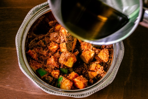 adding mustard oil to the mango pickle masala