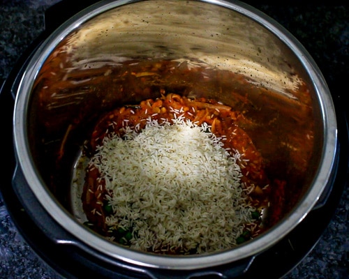 Adding rice to tomato, spice mixture