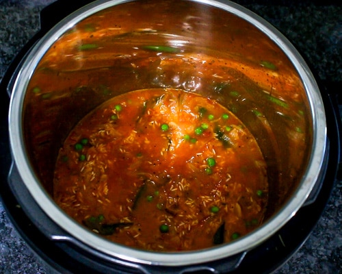 adding water to rice, tomato mixture