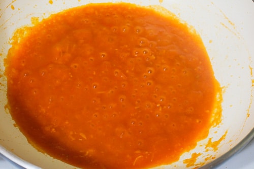 adding cooked tomato puree in the pan