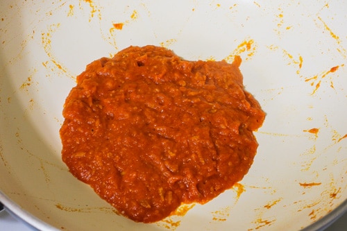 tomato puree is cooked till thick paste