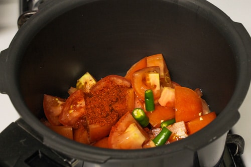 tomatoes, green chilies and red chili powder in pressure cooker