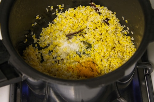 adding soaked dal-rice, salt and turmeric powder in cooker