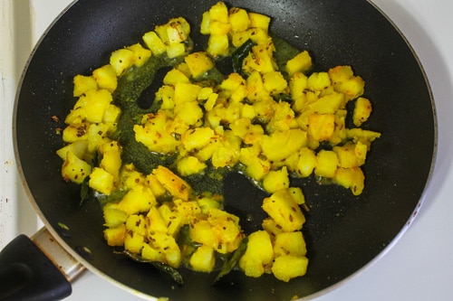 potatoes are mixed with tempering spices