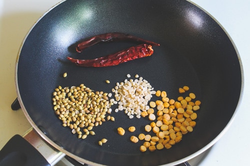 chana dal, urad dal, coriander seeds and red chilies in a pan