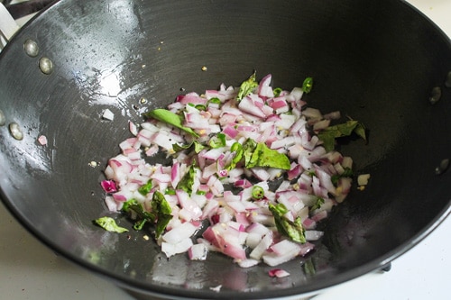 adding onions, curry leaves, green chilies into the oil