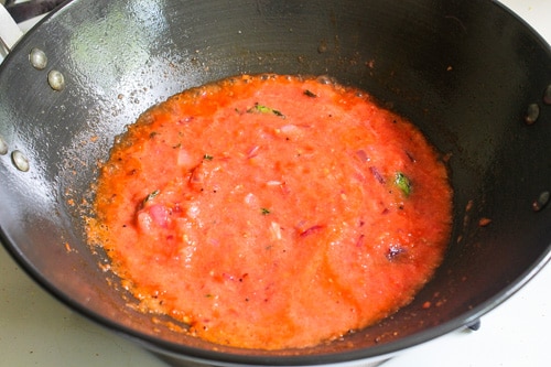 Adding tomato puree to the onion mixture