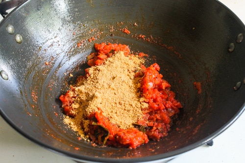 adding freshly ground masala to the tomato mixture