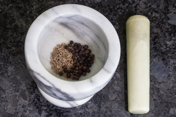 cumin seeds and peppercorns in mortar and pestle