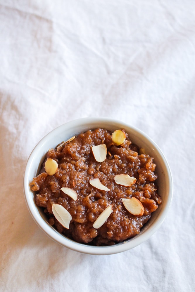 Singhare ke aate ka halwa in a bowl garnished with sliced almonds.