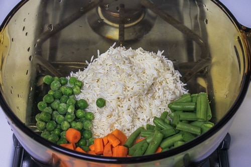 Soaked rice and veggies in a saucepan