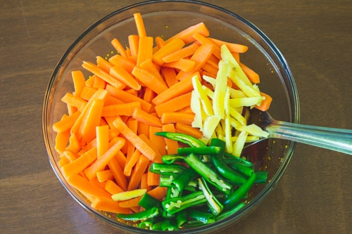 adding carrot, ginger and green chiil to pickle masala