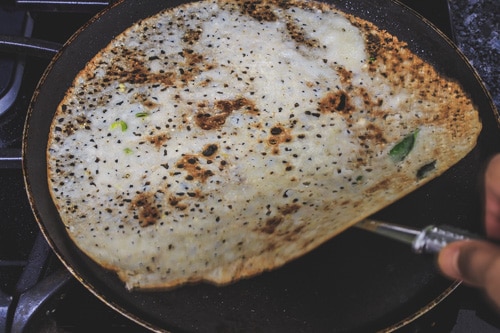 lifting the rava dosa from pan