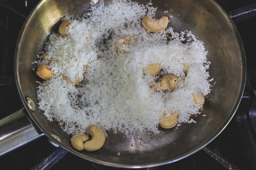 adding dry coconut to roasted casehws