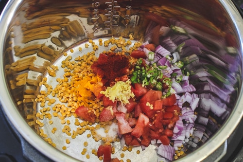 adding dal, spices, onion, tomato