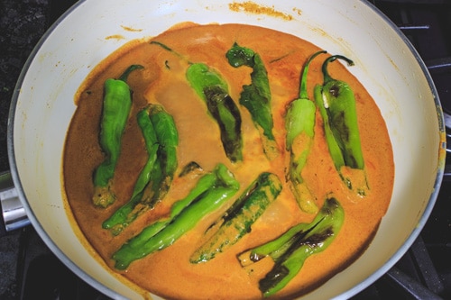 adding chilies to salan gravy