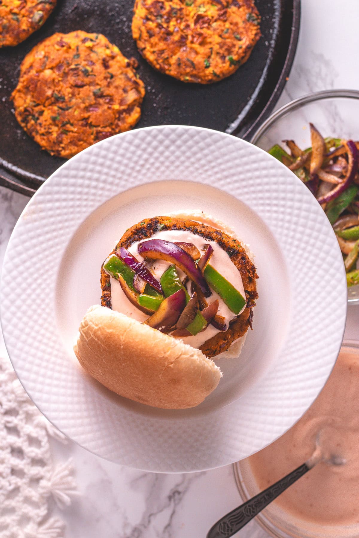 Kidney bean burger in a plate with more patties in the side.