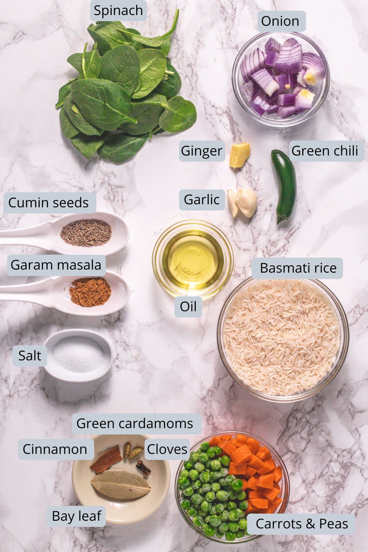 Palak rice ingredients in bowls, spoons and marble surface with labels.