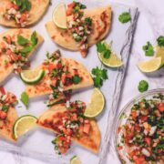 potato taco on a board with garnish of cilantro and lime slices