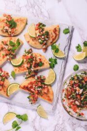 potato taco on a board with garnish of cilantro and lime slices