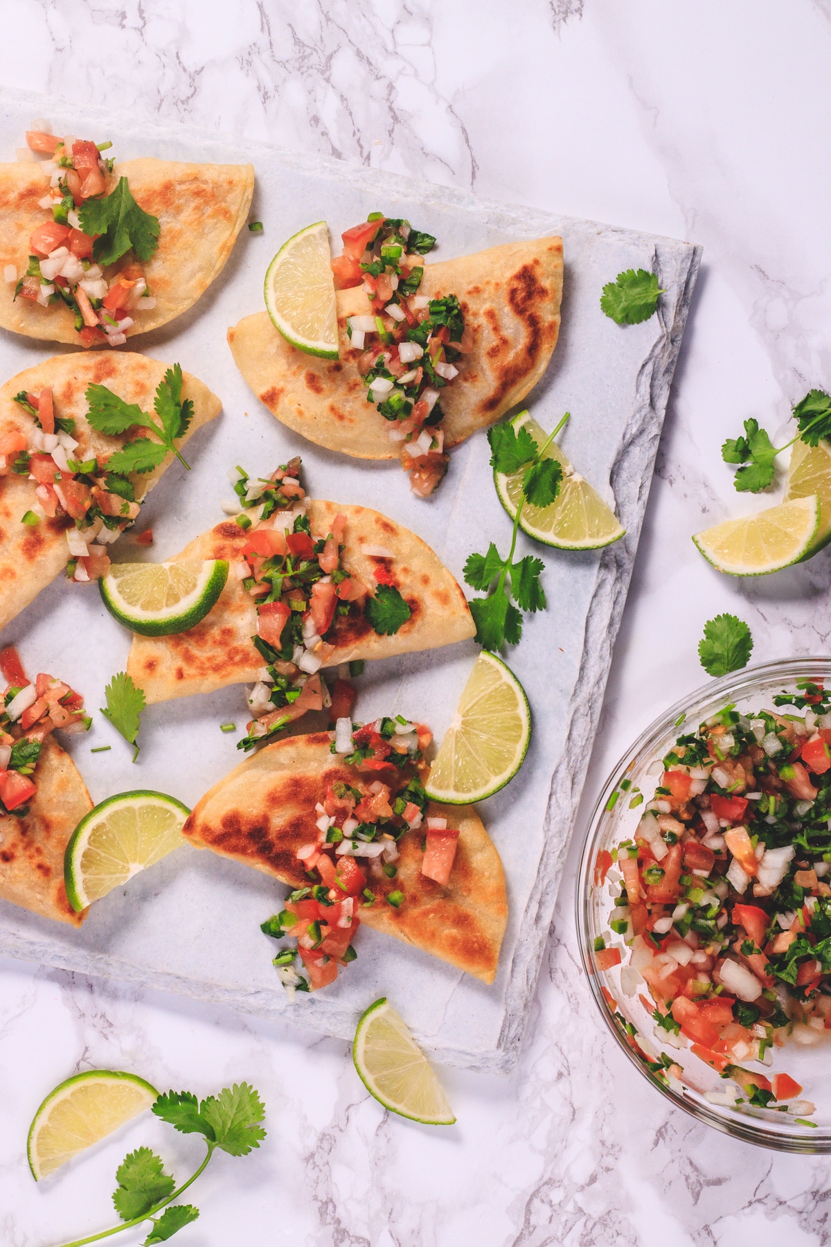 Potato taco on a board with a garnish of cilantro and lime slices.