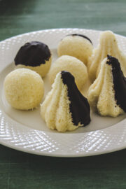 Image of chocolate coated coconut modak and ladoo on a plate