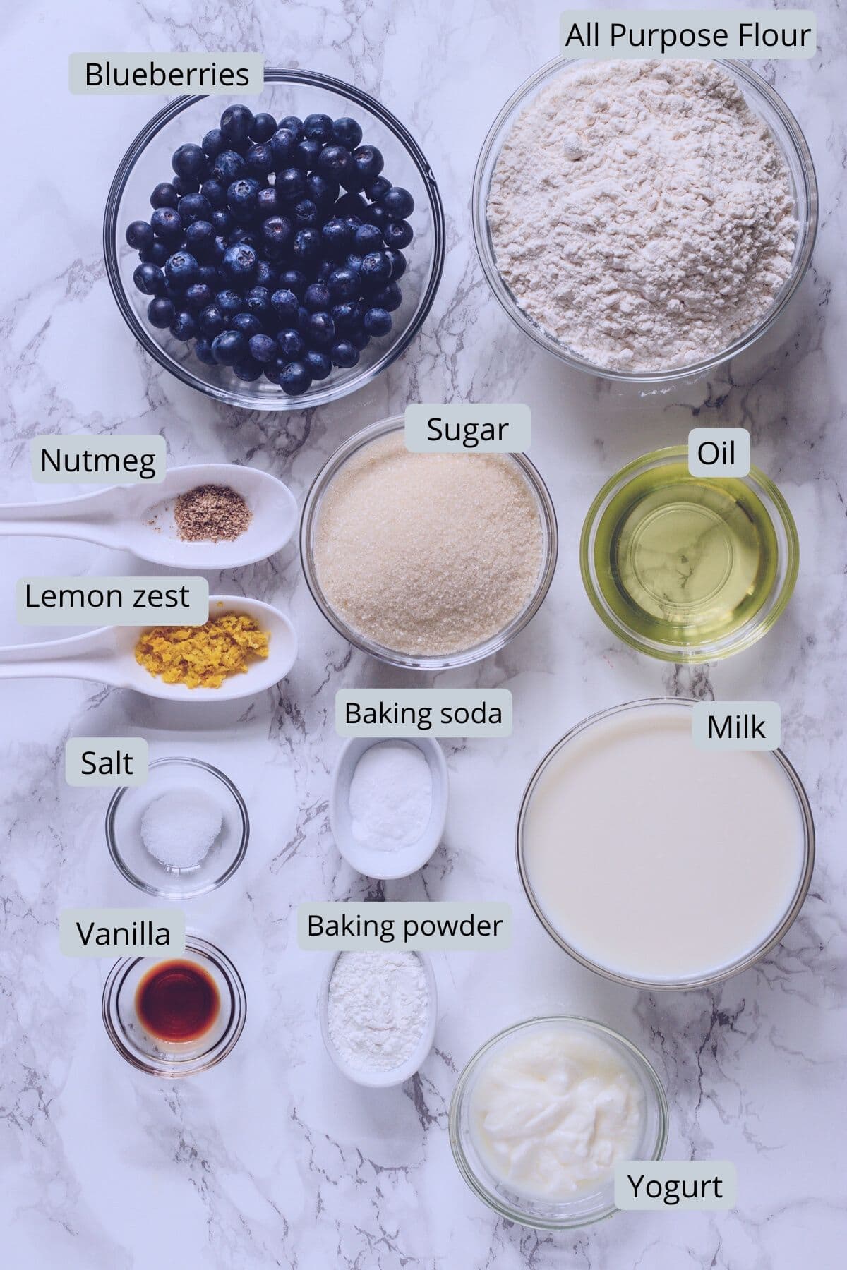 Eggless blueberry muffins ingredients into individual bowls with labels.